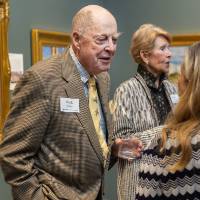 Hank Feeley standing and chatting with event guest by artwork